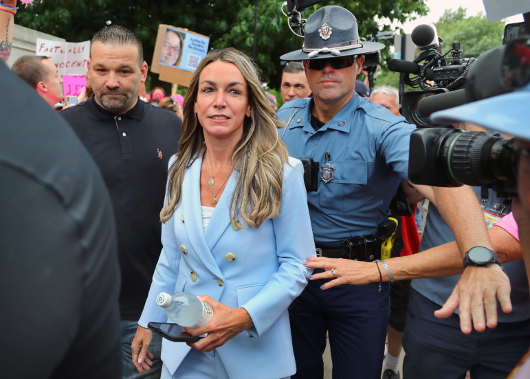 Karen Read walks outside a courthouse in a light blue suit.