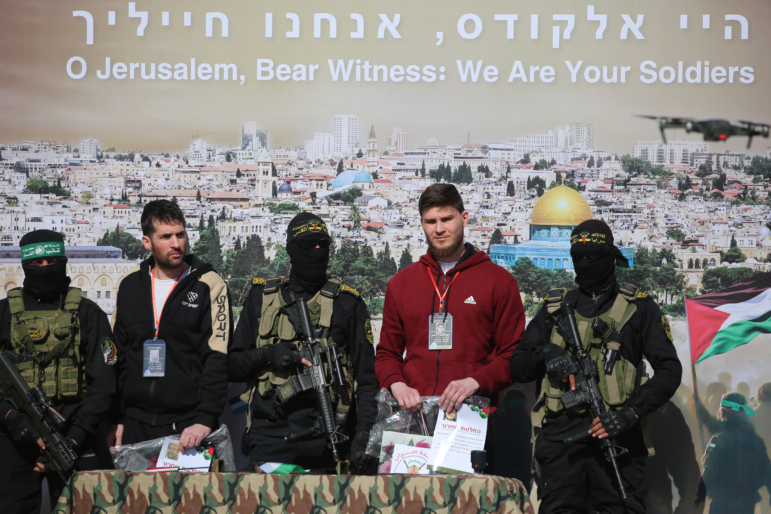 Israeli-Russian hostage Sasha Trupanov (second right) and fellow captive, Israeli-American Sagui Dekel-Chen (second left), stand on stage next to Palestinian militants during their handover to a Red Cross team in Khan Younis, in the southern Gaza Strip, on Feb. 15, as part of the sixth hostage-prisoner exchange between Israel and Hamas. Hamas says it has held direct talks with the U.S. about hostages.