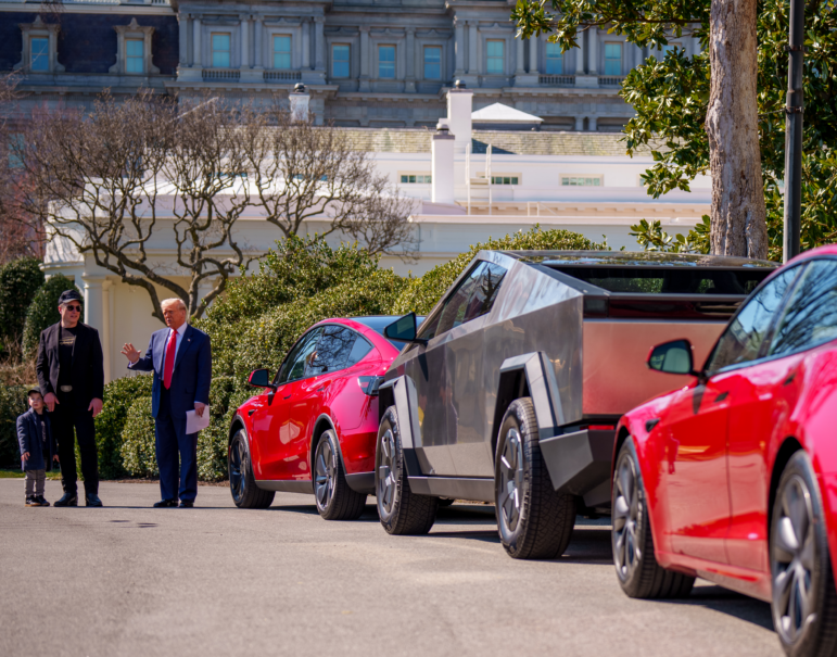 President Trump, accompanied by Tesla CEO Elon Musk and his son X Æ A-Xii, speaks next to a line of Tesla vehicles on the South Lawn of the White House on Tuesday. Trump said he would purchase a Tesla vehicle in what he calls a "show of confidence and support" for Musk. But while Musk is very popular among Republicans, Democrats remain more interested in purchasing electric vehicles.