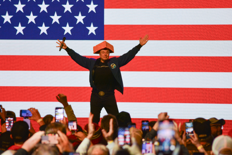 Elon Musk wears a cheesehead hat as he speaks during a rally in Green Bay, Wisc. on March 30, 2025. An election to choose a new state Supreme Court justice takes place Tuesday and Musk has contributed millions to the race, hoping to secure a win for the conservative candidate.
