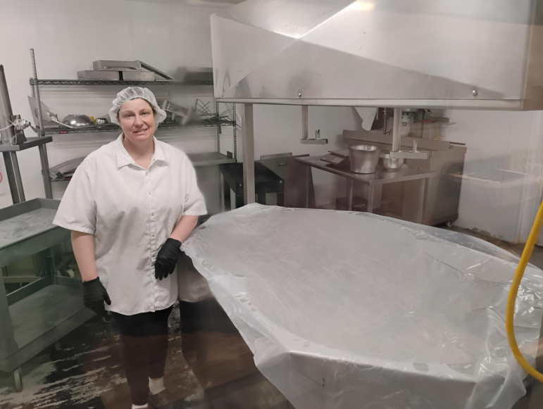 Tammy Fritsch, a dairy farmer from Freedom, Wisc., stands next to her cheese vat. She has been waiting on thousands of dollars in promised federal funds. On Friday, the USDA released those funds to farmers like Fritsch.