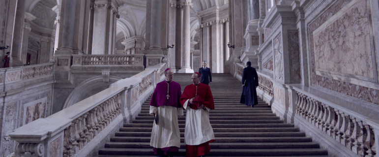 Cardinal O'Malley (Brían F. O'Byrne) and Cardinal Lawrence (Ralph Fiennes) confer in Conclave.