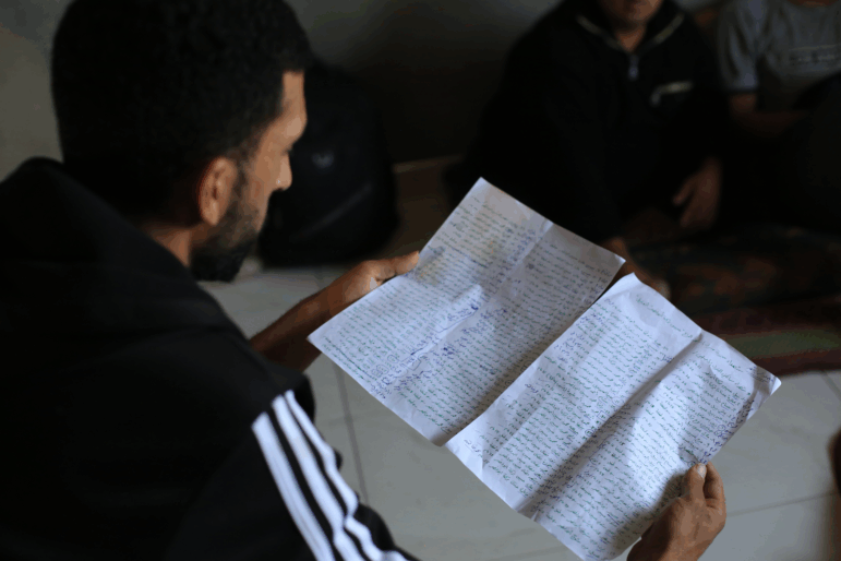Mohammed Nabil Abu Naser holds a handwritten list of family members killed in an October 2024 Israeli strike in northern Gaza.
