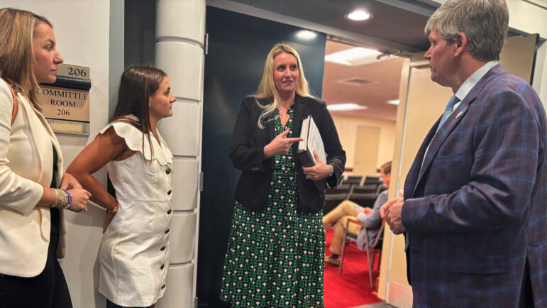 Lulu Gribbin, an Alabama teenager who survived a shark attack in 2024, speaks with attorney Charlanna Skaggs and Alabama lawmaker Rep. David Faulkner at the Alabama Statehouse.