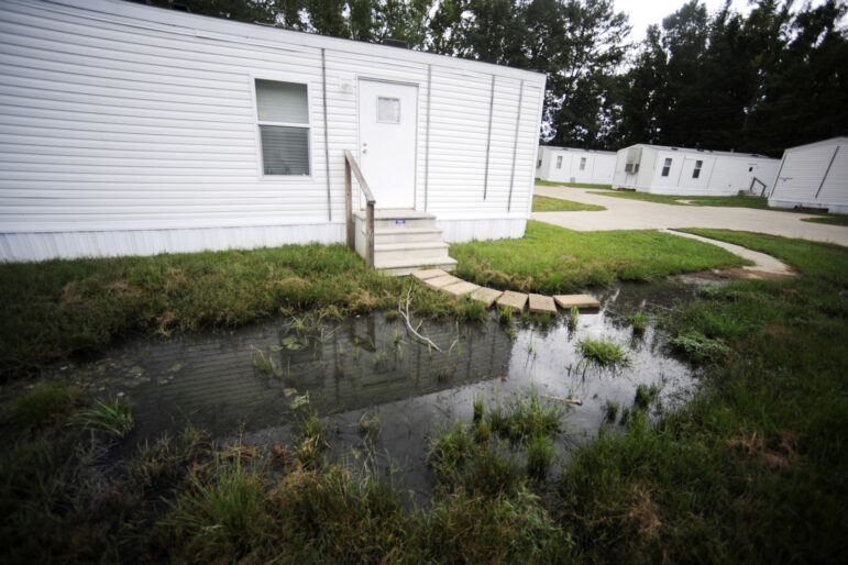 Fetid water pools outside a mobile home in a small mobile home park in rural Hayneville.