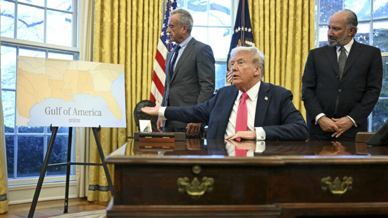 President Donald Trump gestures to a poster that says "Gulf of America."