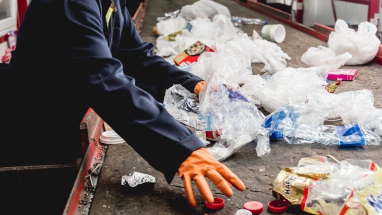 A worker sorts out trash at a recycling plant.