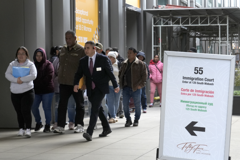 After waiting in a queue, people are led into a downtown Chicago building where an immigration court presides, Nov. 12, 2024.