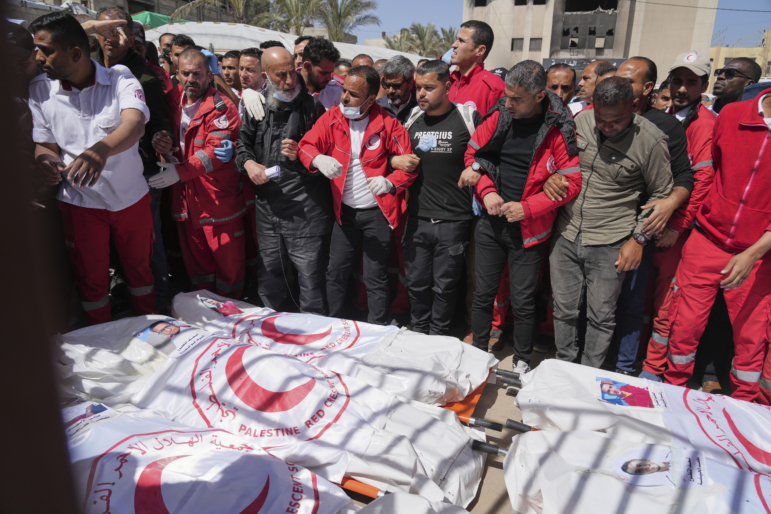 Mourners gather around the bodies of eight Red Crescent emergency responders, recovered in Rafah a week after an Israeli attack, as they are transported for burial from a hospital in Deir al-Balah, Gaza Strip, March 31. (AP Photo/Abdel Kareem Hana)