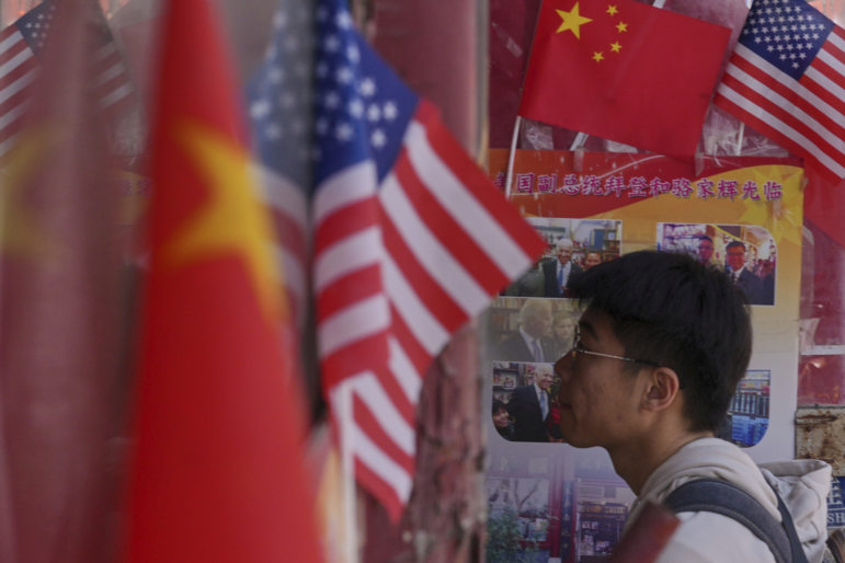 A man walks into a merchandise store displaying Chinese and United States' national flags, in Beijing on April 3.