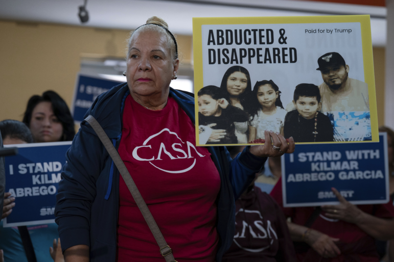 Supporters hold up signs as Jennifer Vasquez Sura, the wife of Kilmar Abrego Garcia of Maryland, who was mistakenly deported to El Salvador, speaks during a news conference at CASA's Multicultural Center in Hyattsville, Md., Friday, April 4, 2025. (AP Photo/Jose Luis Magana)