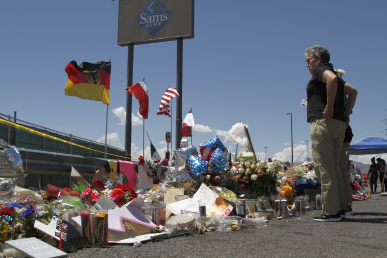 In this Aug. 12, 2019 photo, mourners visit the makeshift memorial near the Walmart in El Paso, Texas.