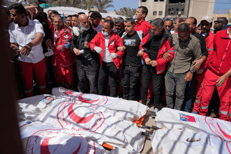 Mourners gather around the bodies of 8 Red Crescent emergency responders, recovered in Rafah a week after an Israeli attack, as they are transported for burial from a hospital in Deir al-Balah, Gaza Strip, on Monday, March 31, 2025.