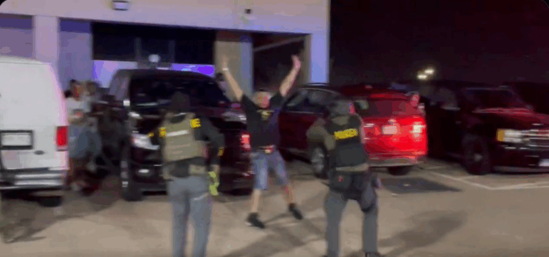 This screenshot from a video posted on X by the Drug Enforcement Administration's Rocky Mountain Division shows law enforcement officers raiding a nightclub in Colorado Springs.