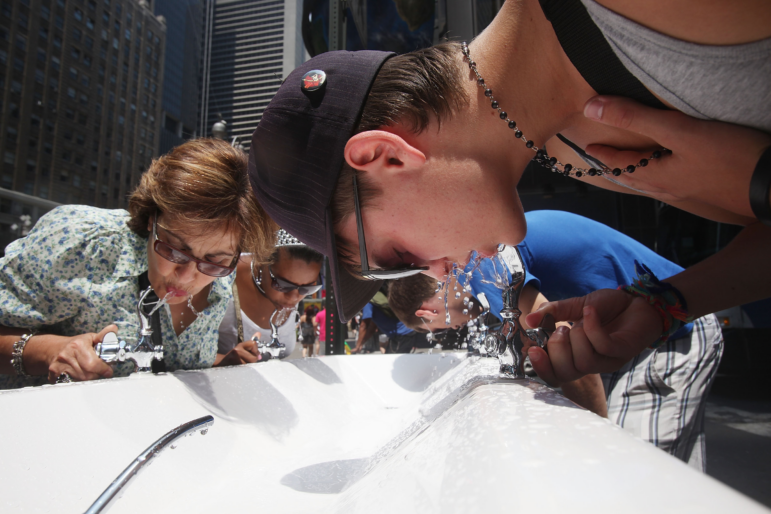 People drink water from a six-spigot water fountain in New York City on July 7, 2010