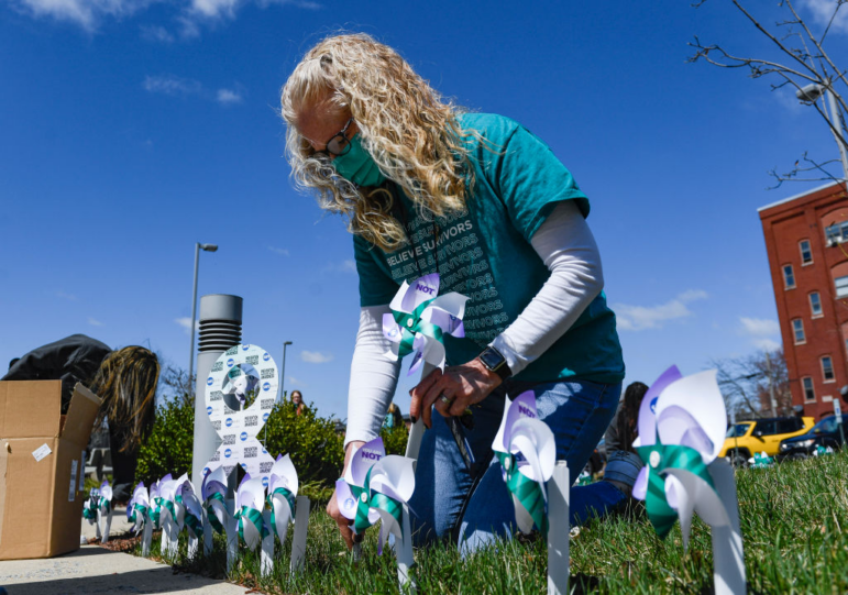 In April, many local communities hold events to raise awareness of sexual violence as part of their prevention efforts, such as this event in Reading, Pa., in 2021, where a staffer at Safe Berks, a violence prevention group, puts up a display. Sexual violence prevention efforts often get funding and support from the federal government.