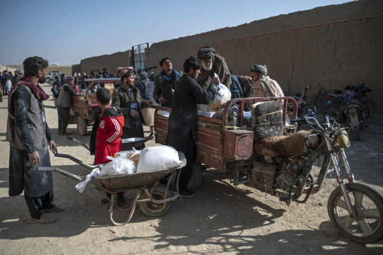 Afghan men load food packets on a vehicle that were distributed as an aid by the World Food Programme (WFP) organisation at Nawabad Kako Sahib area in Baraki Barak district of Logar Province on January 7, 2024.