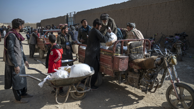 Afghan men load food packets on a vehicle that were distributed as an aid by the World Food Programme (WFP) organisation at Nawabad Kako Sahib area in Baraki Barak district of Logar Province on January 7, 2024.