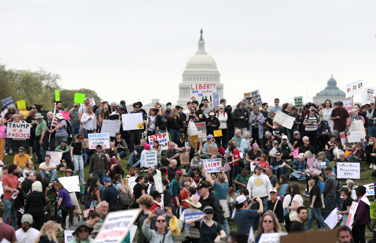 Protesters attend a "Hands Off" rally Saturday to demonstrate against President Trump on the National Mall in Washington, D.C.