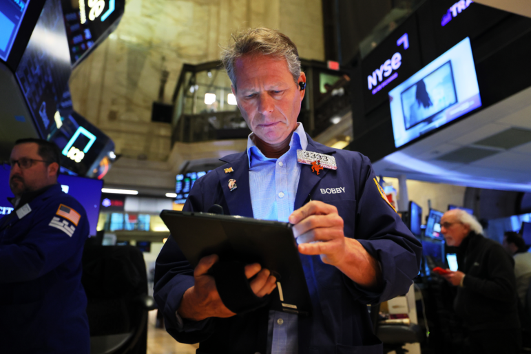 Currency traders watch computer monitors near a screen showing news reporting with a picture of President Trump at a foreign exchange dealing room in Seoul on Tuesday.