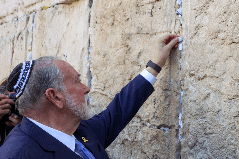The new U.S. Ambassador to Israel Mike Huckabee places a note given to him from President Trump in the cracks of the Western Wall, during Huckabee's visit to the holy site in the old city of Jerusalem on April 18.