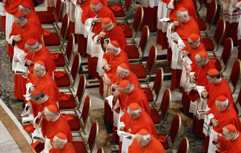 Three rows of cardinals dressed in red and white look on as the body of Pope Francis is transferred into the Basilica at St Peter’s Square in Vatican City on Wednesday.
