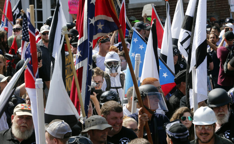 White nationalist demonstrators walk into the entrance of Lee Park surrounded by counter demonstrators in Charlottesville, Virginia.
