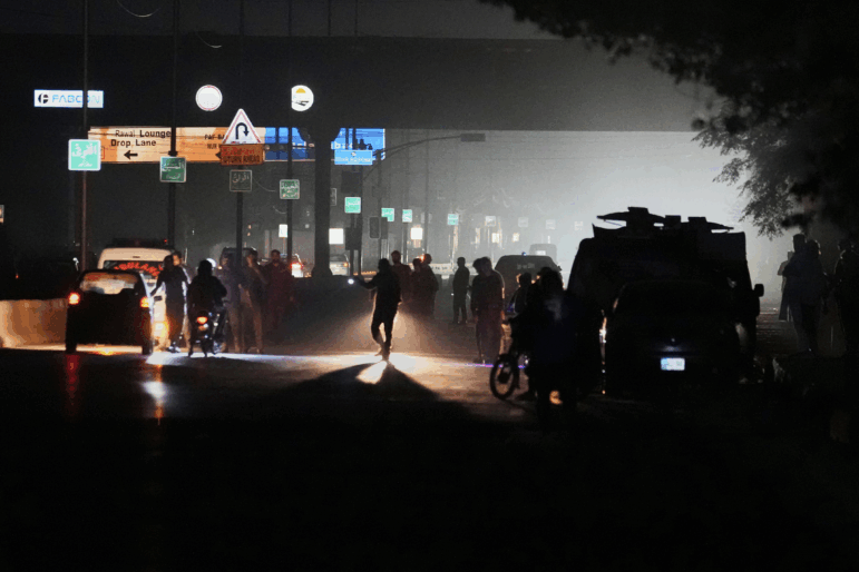 Pakistani police officers remove vehicles and people from the main entry of Nur Khan airbase following an Indian missile strike in Rawalpindi, Pakistan, on Saturday.