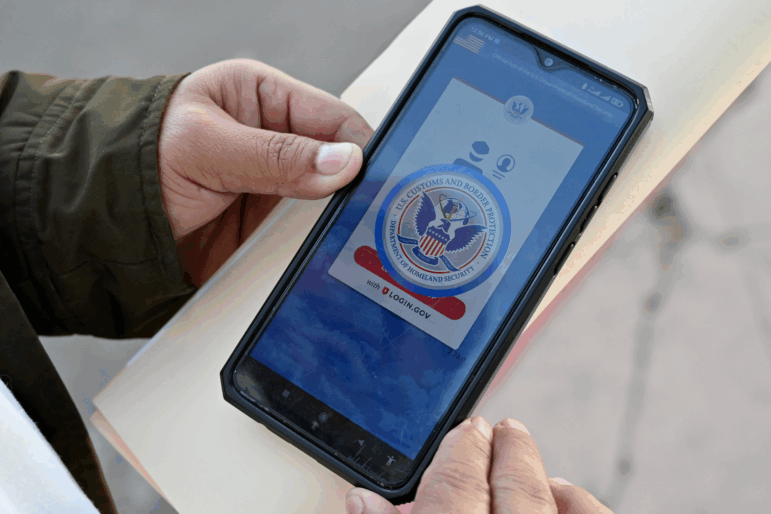 An asylum seeker with a canceled appointment to enter the United States waits to speak to a Mexican immigration official as he reviews the CBP One app at the El Chaparral border crossing port in Tijuana, Mexico, in January 2025.