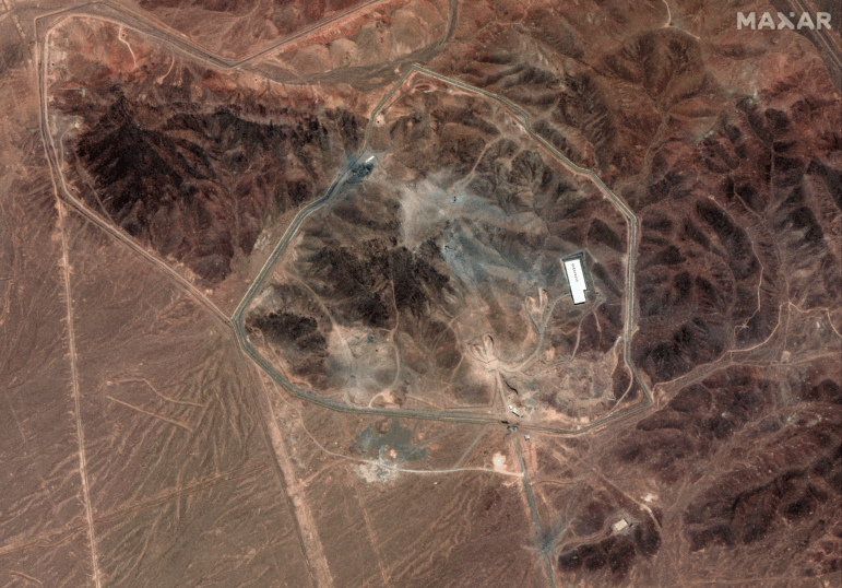 A satellite photo of Iran's Fordo fuel enrichment facility taken on 24 June shows debris (grey) from a U.S. strike employing several bunker-busting weapons. The Israeli Air Force destroyed additional roads and surface facilities in a subsequent strike.