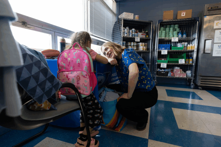 Megan Mainzer, the McKinney-Vento liaison for Middletown Public Schools in Rhode Island, speaks with a young girl at a school food and clothing pantry that's managed, in part, with federal grant money.