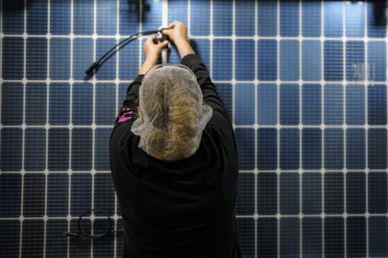 An employee works on a solar panel inside the Hanwha Qcells Solar plant, Monday, Oct. 16, 2023, in Dalton, Ga. The Korean company is opening what it says is the first solar panel factory to begin production in the U.S. since the passage of President Joe Biden’s signature climate legislation. (AP Photo/Mike Stewart)