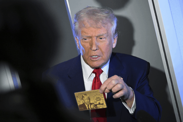 President Donald Trump holds up the $5 million gold card as he speaks to reporters while in flight on board Air Force One, en route to Miami, Thursday, April 3, 2025.