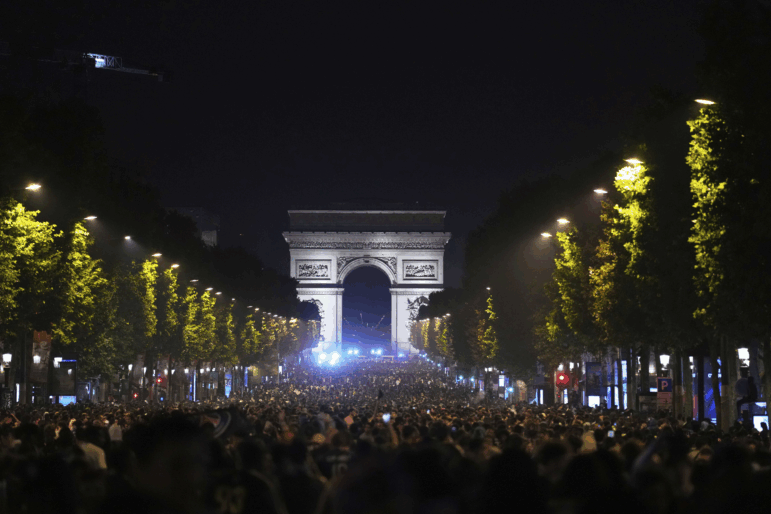 Soccer fans celebrate PSG's victory on the Champs-Elysees avenue, with the Arc de Triomphe in background, after the Champions League final soccer match between Paris Saint-Germain and Inter Milan, Sunday, June 1, 2025 in Paris.