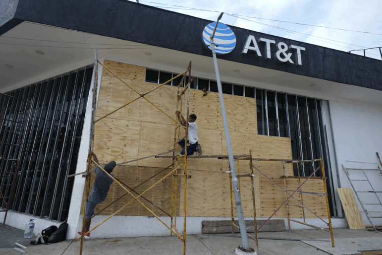 Workers board up a storefront as they prepare for the arrival of Hurricane Erick, in Acapulco, Mexico on Wednesday.