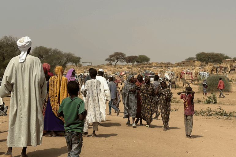 People who fled the Zamzam camp for the internally displaced after it fell under RSF control, walk in a makeshift encampment in an open field near the town of Tawila in war-torn Sudan's western Darfur region on April 13, 2025.