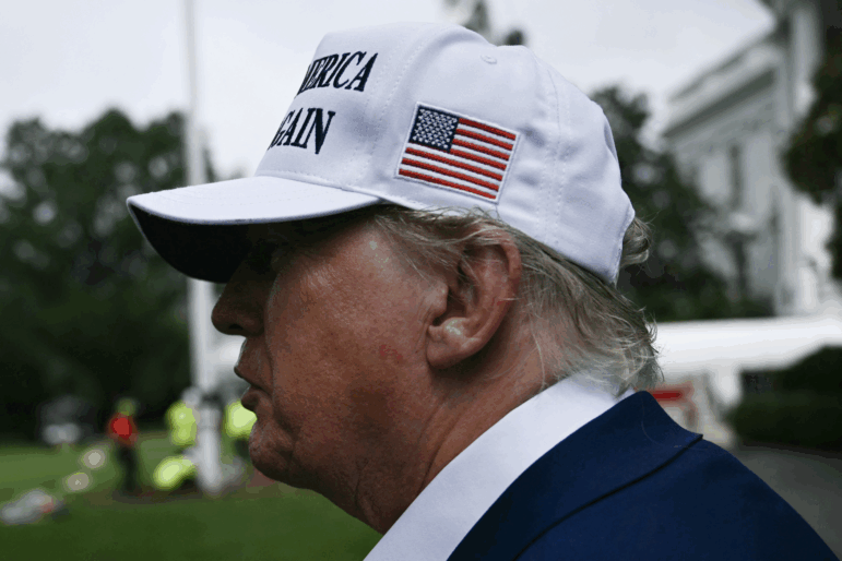President Trump speaks to the press as workers install a large flag pole on the South Lawn of the White House in Washington, DC on June 18, 2025.