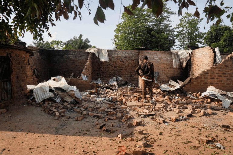A man stands in front of a damaged and burnt house following a deadly gunmen attack in Yelwata, Benue State, Nigeria, on June 16, 2025.