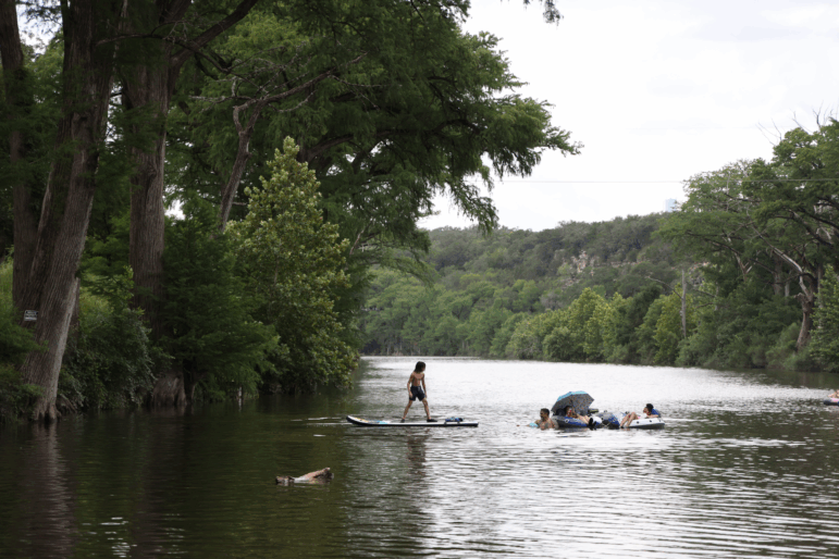 People swim in the Blanco River by a low water crossing on River Road across from 7A Ranch in Wimberley, Texas, on July 9.