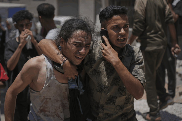 Palestinians react after carrying the bodies of those killed while trying to reach aid trucks entering northern Gaza through the Zikim crossing with Israel, at Shifa Hospital in Gaza City, Sunday.