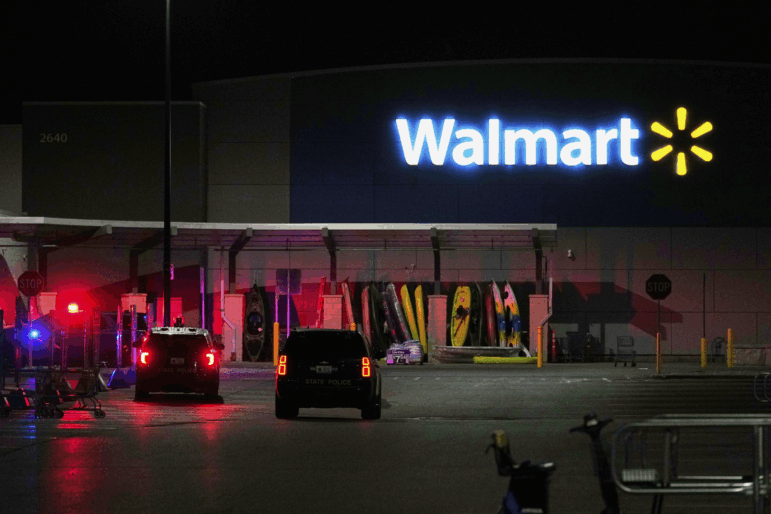 Law enforcement officers are seen stationed outside a Walmart where 11 people were stabbed in a violent attack Saturday, July 26, 2025, in Traverse City, Mich.