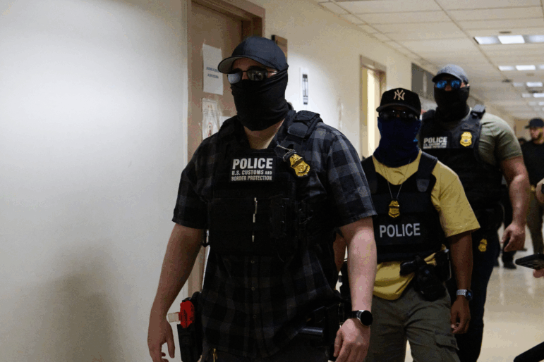 Federal agents working for U.S. Immigration and Customs Enforcement (ICE) detain immigrants and asylum seekers reporting for immigration court proceedings at the Jacob K. Javits Federal Building's U.S. Immigration Court in New York, New York, Thursday. Some Democratic lawmakers are proposing legislation that would prohibit federal agents from wearing masks.