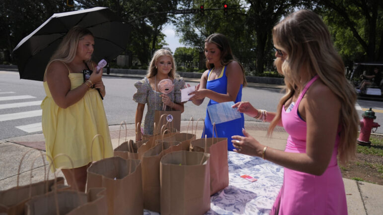 Sorority recruits talk with former sorority members near sorority row at the University of Alabama.