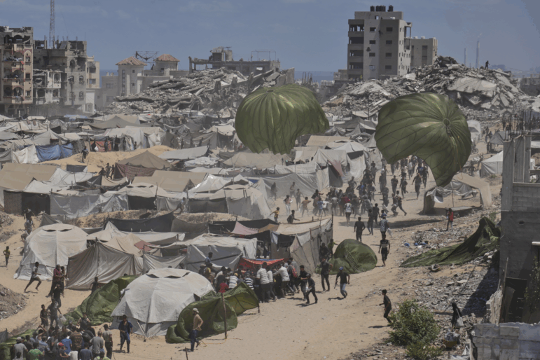 Palestinians rush to collect humanitarian aid airdropped by parachutes into Gaza City on Aug. 7, 2025.