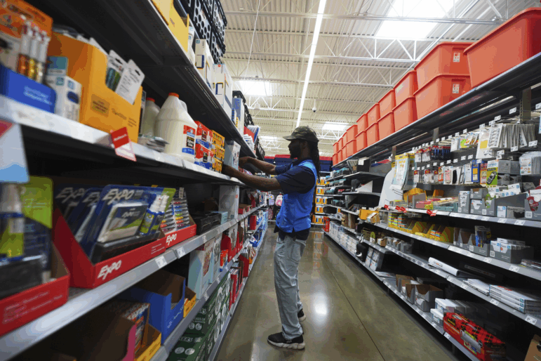 Walmart employee Tim Taylor adjusts items for sale in the back-to-school section of a store in Dallas.