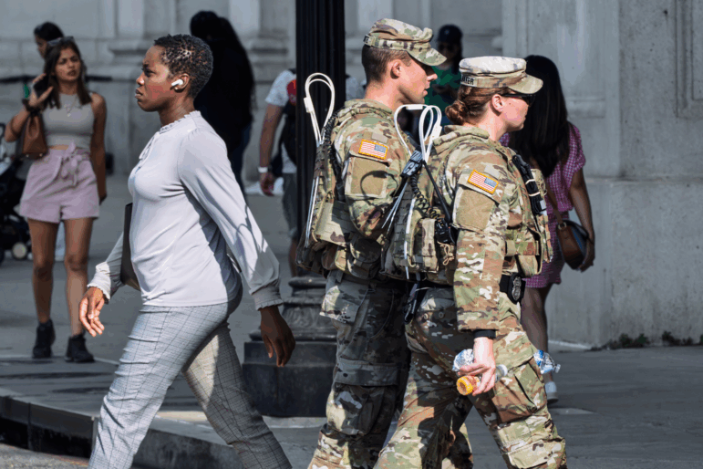 National Guard personnel keep watch as travelers arrive at the entrance to Union Station near the Capitol, in Washington, D.C., on Thursday, Aug. 14, 2025.
