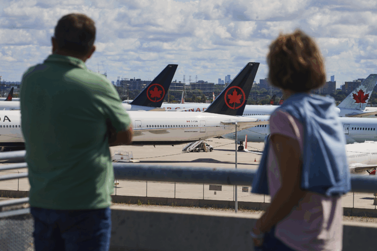 Travelers look out over grounded Air Canada planes as flight attendants picket at Pearson International Airport in Toronto, Monday.