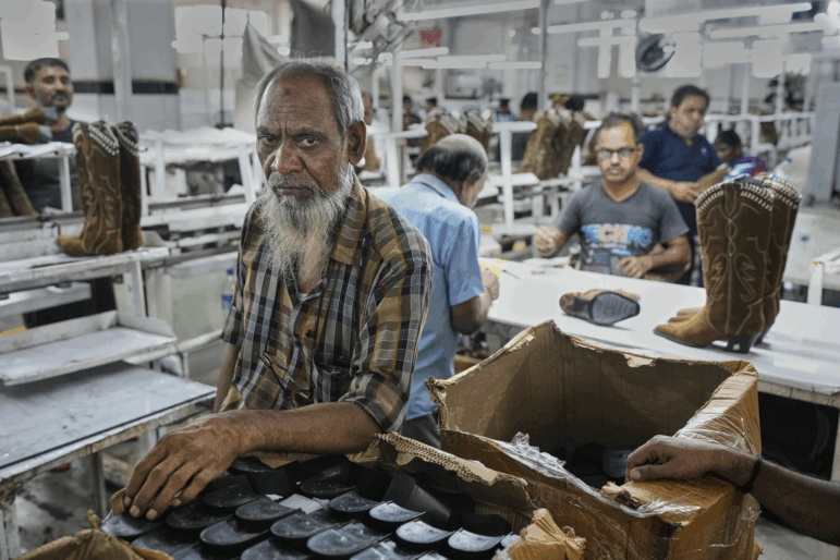 Workers at a manufacturing unit make leather footwear in Agra, India, on Monday.