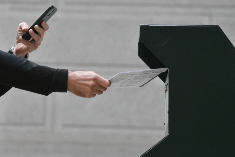 A man photographs himself depositing his ballot in an official ballot drop box in Philadelphia on Oct. 27, 2020.