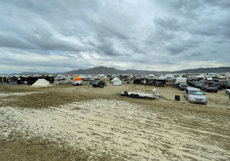 Camps are set on a muddy desert plain on September 2, 2023, after heavy rains turned the annual Burning Man festival site in Nevada's Black Rock desert into a mud pit.